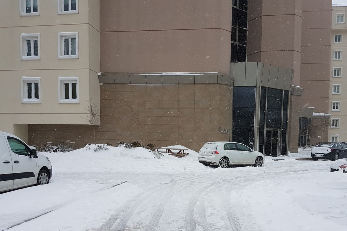 Karla kaplı site içi yol ve bina girişi