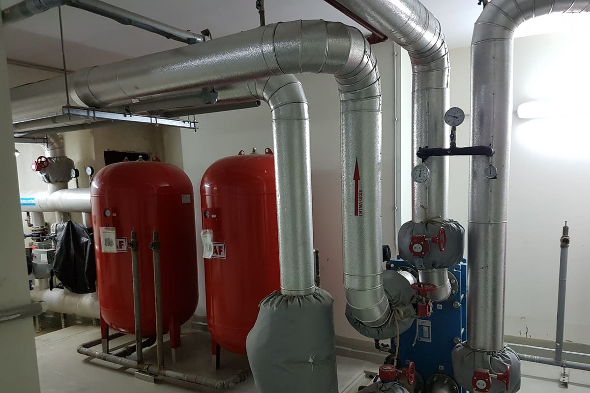 Merkezi ısıtma kazan dairesinde genleşme tankları, pompalar ve yalıtımlı borular